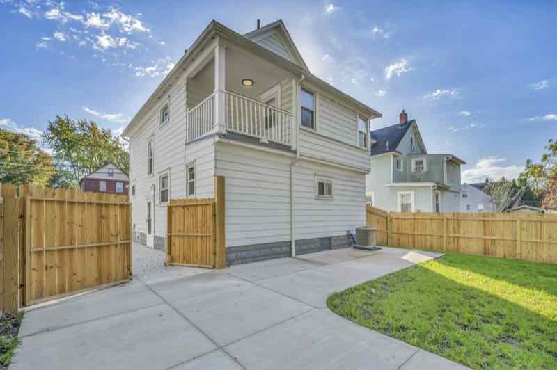 Cedar fence with a drive gate beside a garage pad